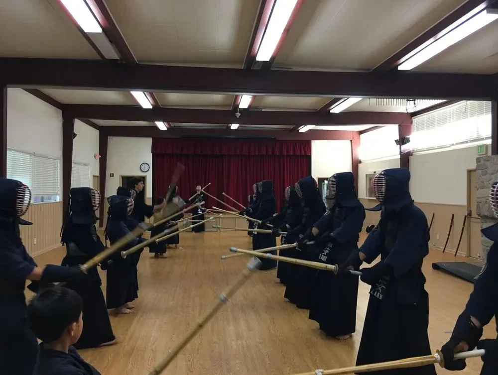 LCKA Kendo practitioners in bogu training in two facing lines inside the dojo.